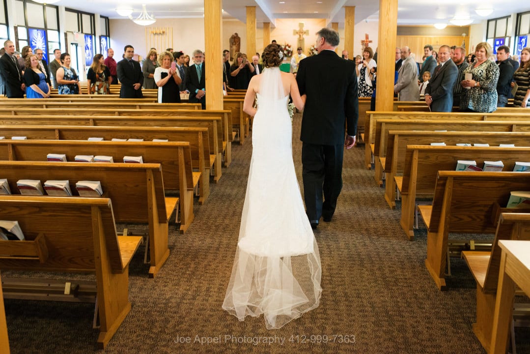 A bride and her father walk down the aisle during her wedding at St. Columbkille.