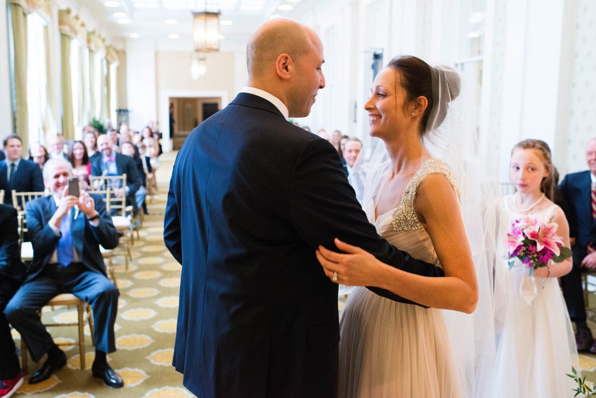 A bride and groom embrace during their wedding ceremony indoors at Bedford Springs Resort