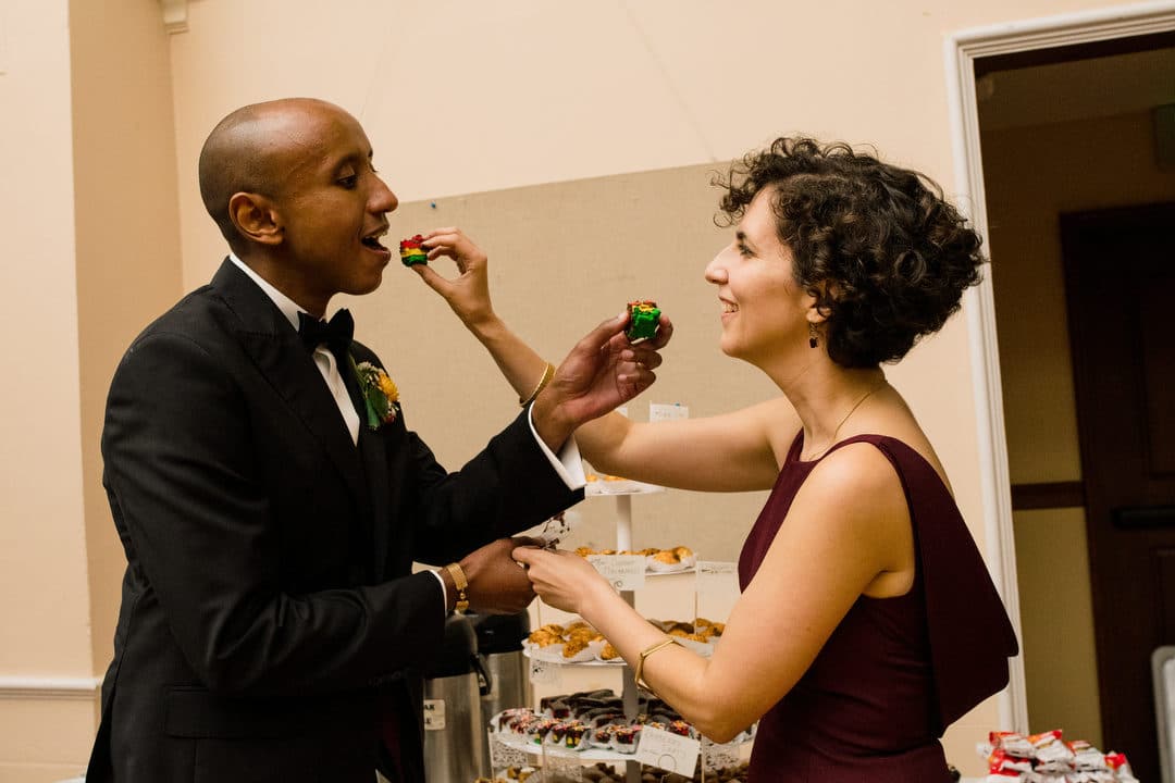 A bride and groom feed each other a piece of cake during their reception in Brookline MA.