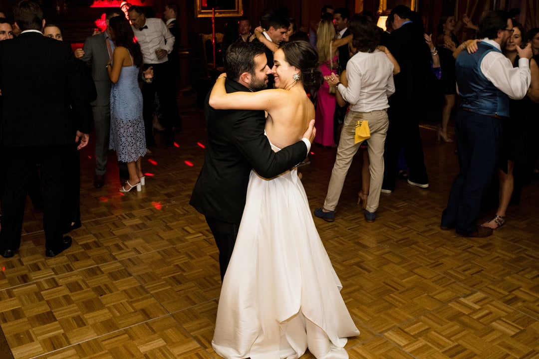 A bride and groom kiss on the dance floor during their wedding at the Duquesne Club.