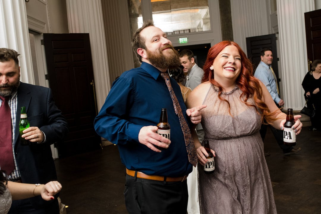 A man with a beard and a woman with bright red hair dance during a wedding reception at the Hotel Monaco in Pittsburgh.