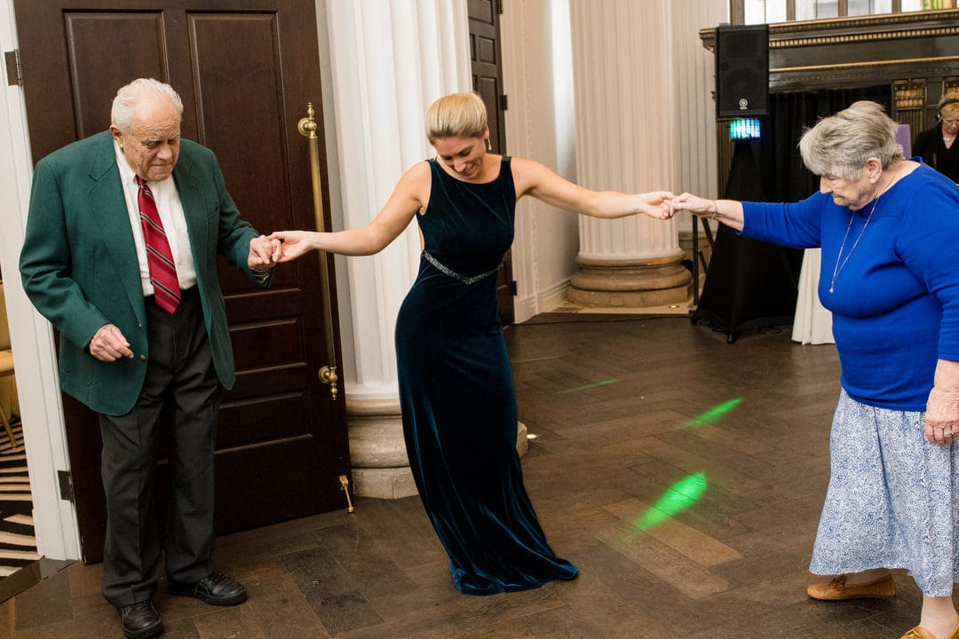 A blond woman dances with her elderly grandparents during a wedding reception at the Hotel Monaco in Pittsburgh.