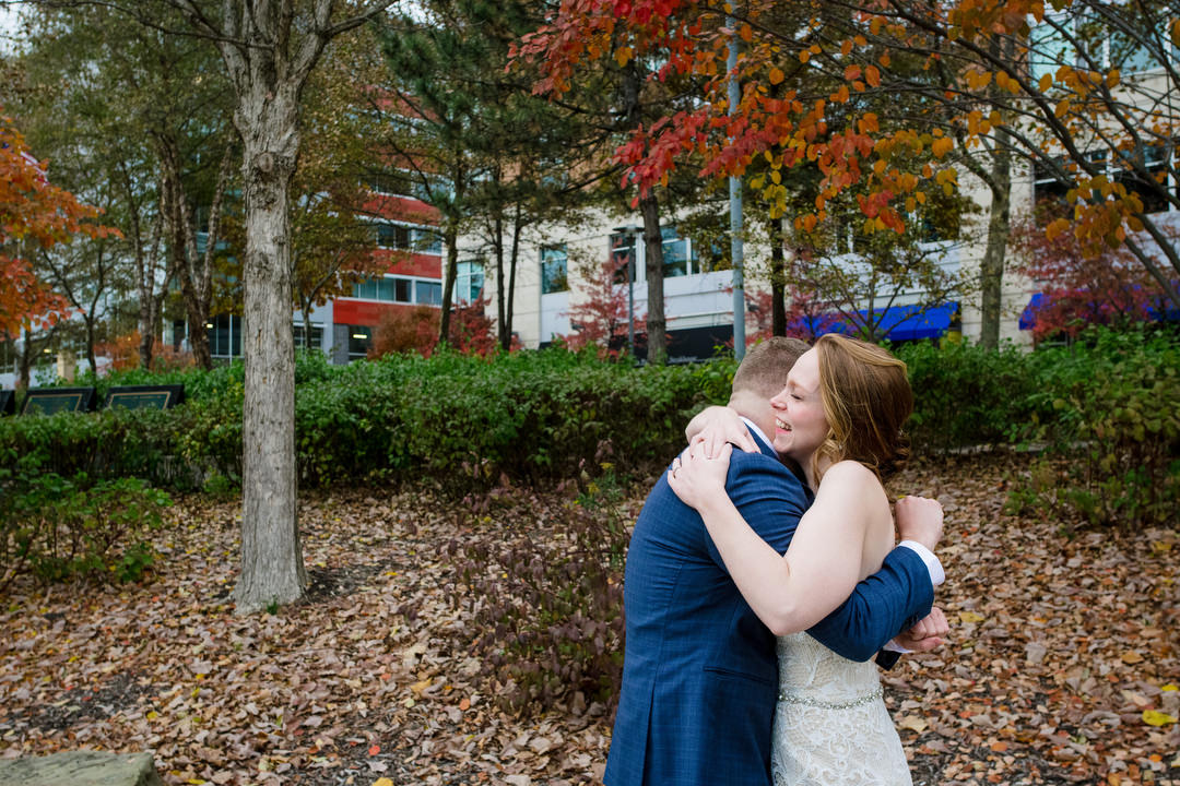A smiling bride embraces her groom on the North Shore of Pittsburgh.