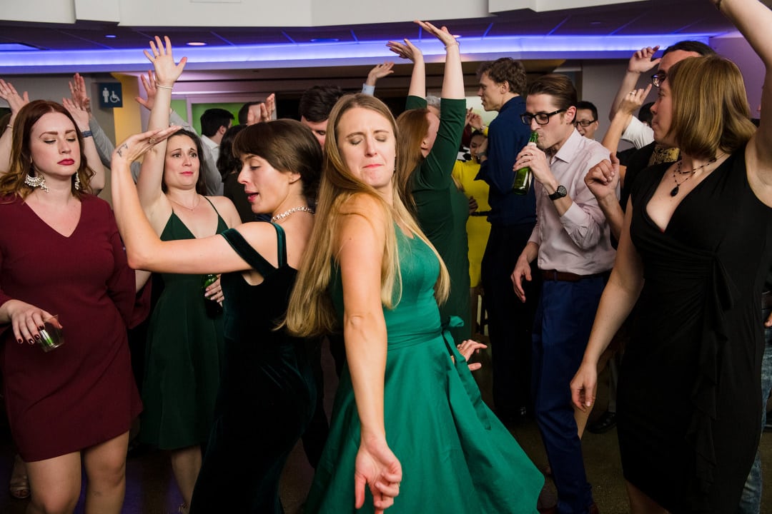 Two women dance back-to-back during a Pittsburgh Aviary wedding.