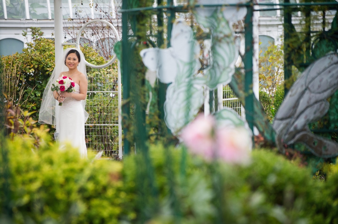 A bride holds her bouquet of flowers in the Children's Discovery Garden before her small wedding at Phipps