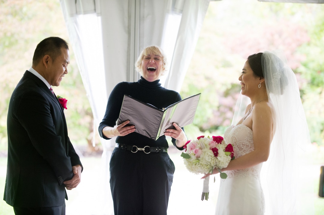 A couple laughs along with their officiant during a small wedding at Phipps