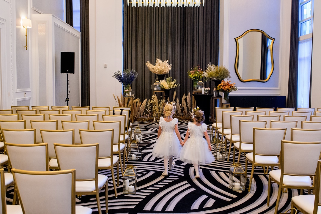Two flower girls walk down the aisle as they practice before a Hotel Monaco Pittsburgh wedding.