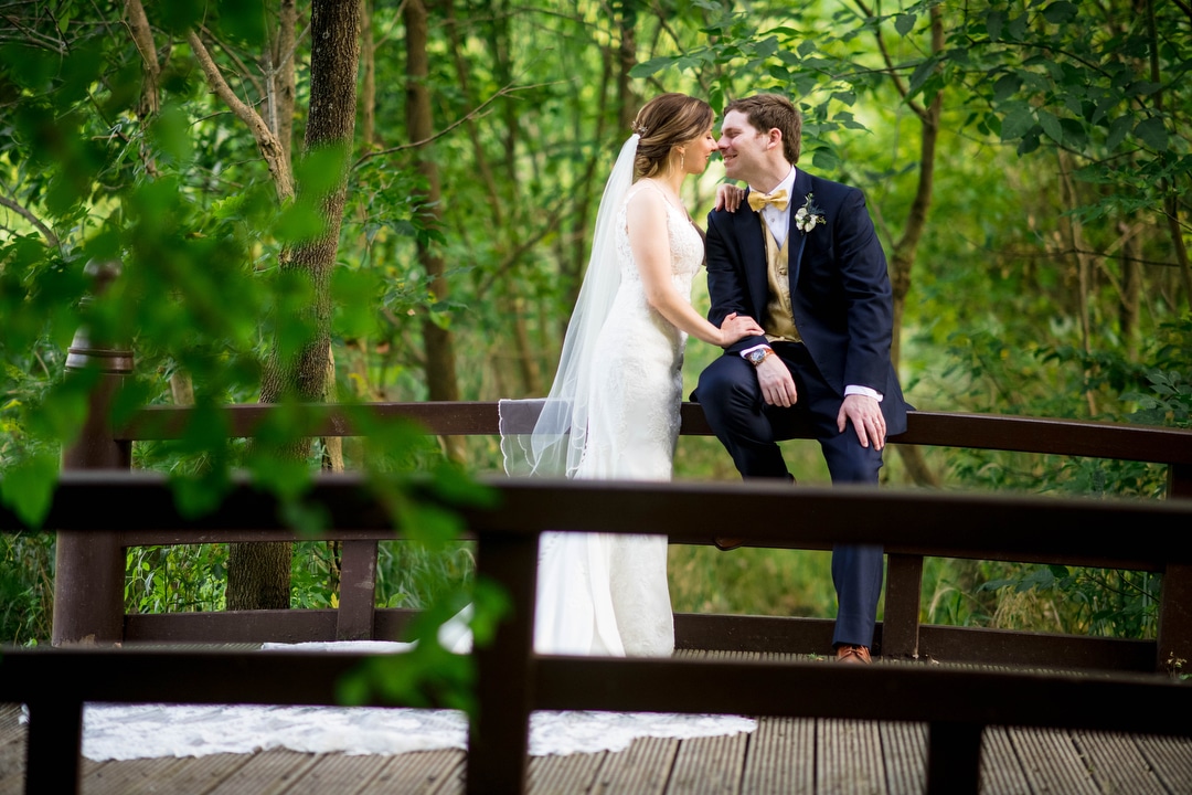 A bride and groom share a kiss on a bridge in South Park in Allegheny County.