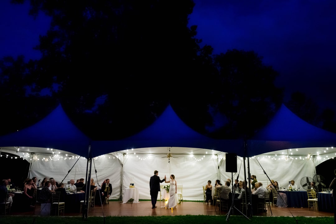 A bride and groom dance in their tented reception under twilight skies at Gilfillan Farm.