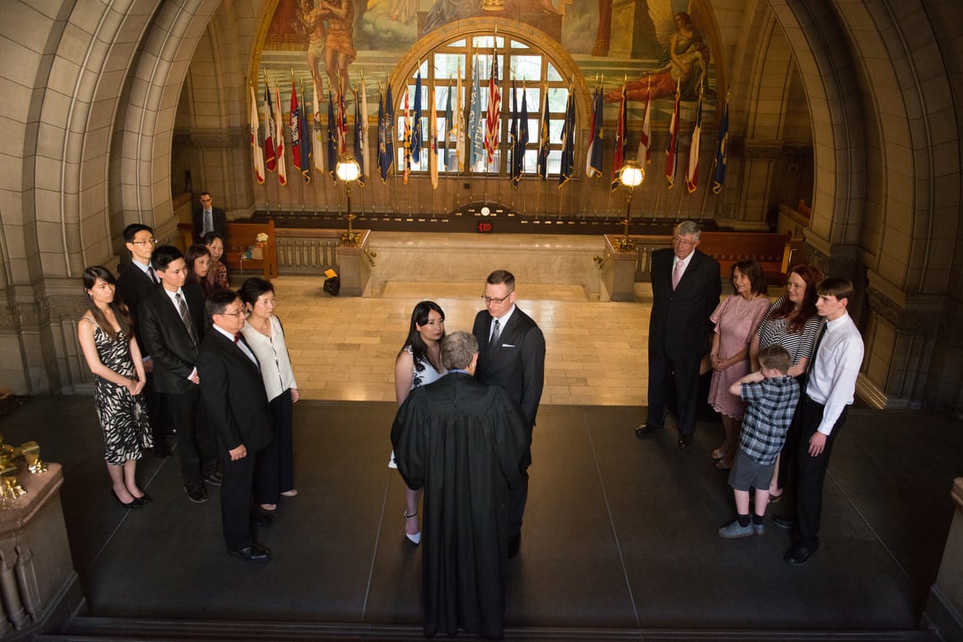 A couple stands in front of a robed judge during their wedding ceremony on the steps of the Allegheny County Courthouse in Pittsburgh.