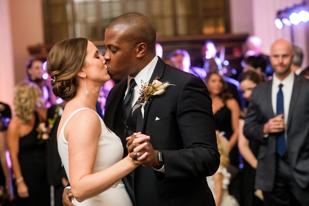 A bride and groom kiss during their first dance.