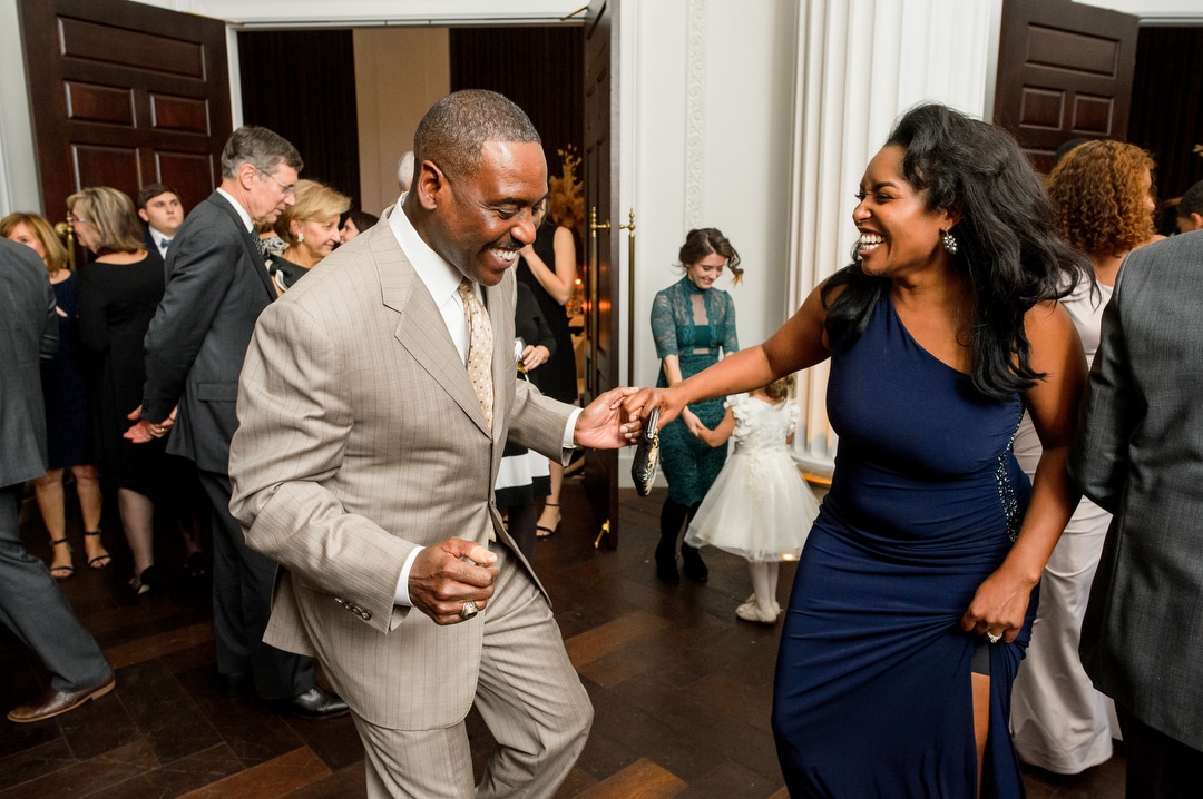 A man in a gray suit dances with a woman in a tight navy blue dress during a wedding reception at the Hotel Monaco in Pittsburgh.