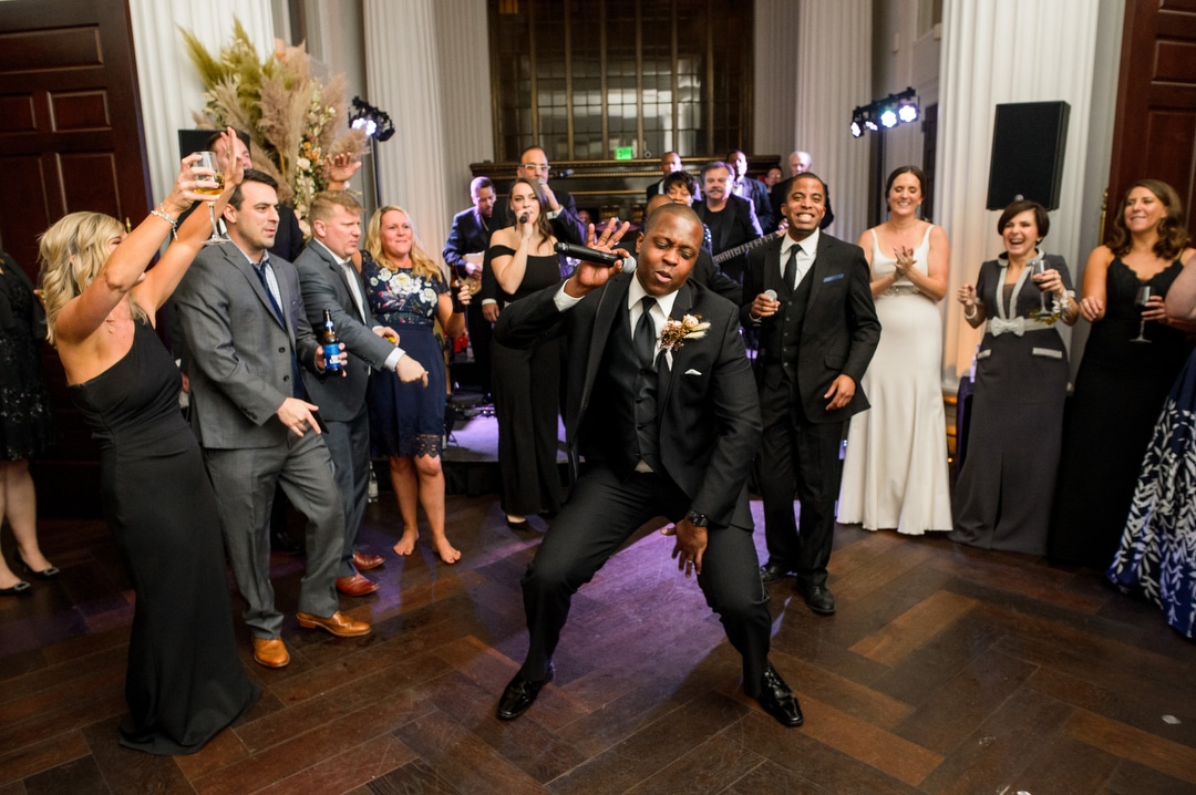 A groom gets down as he sings a song with the band during his wedding at the Hotel Monaco in Pittsburgh.