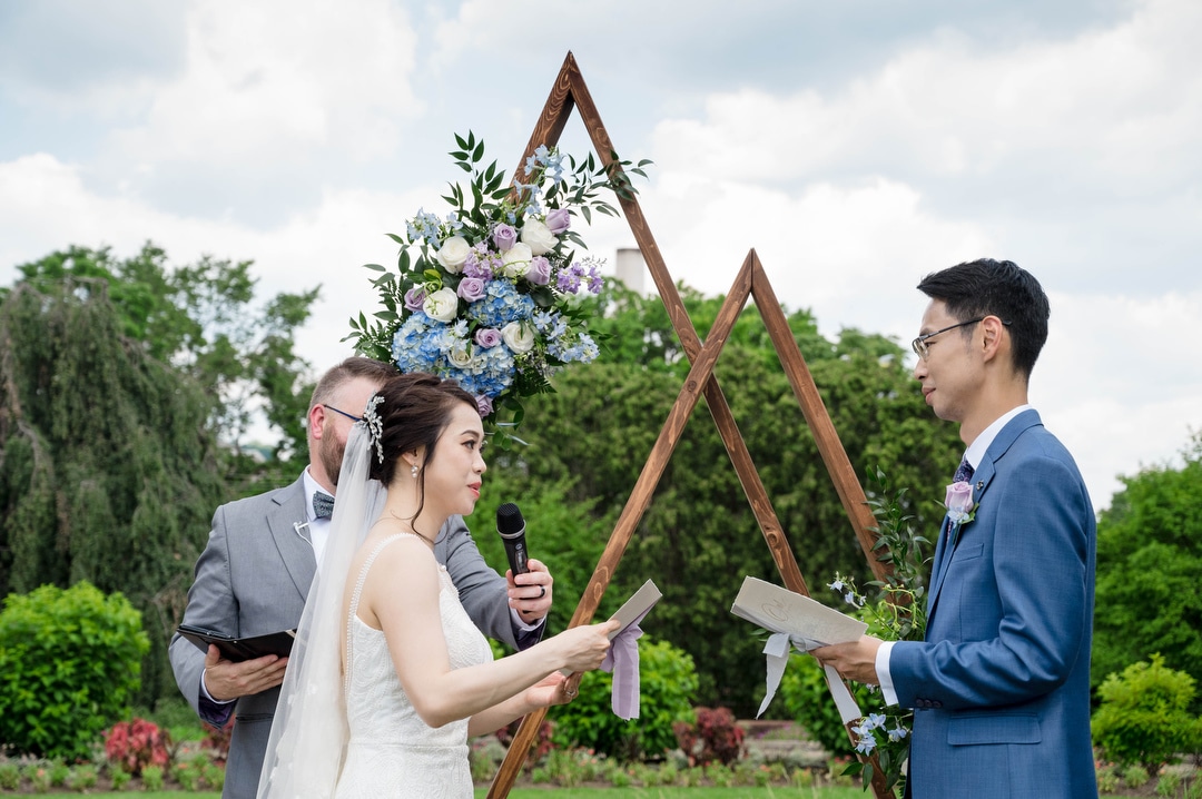 A bride and groom exchange personal vows during their Phipps outdoor wedding.