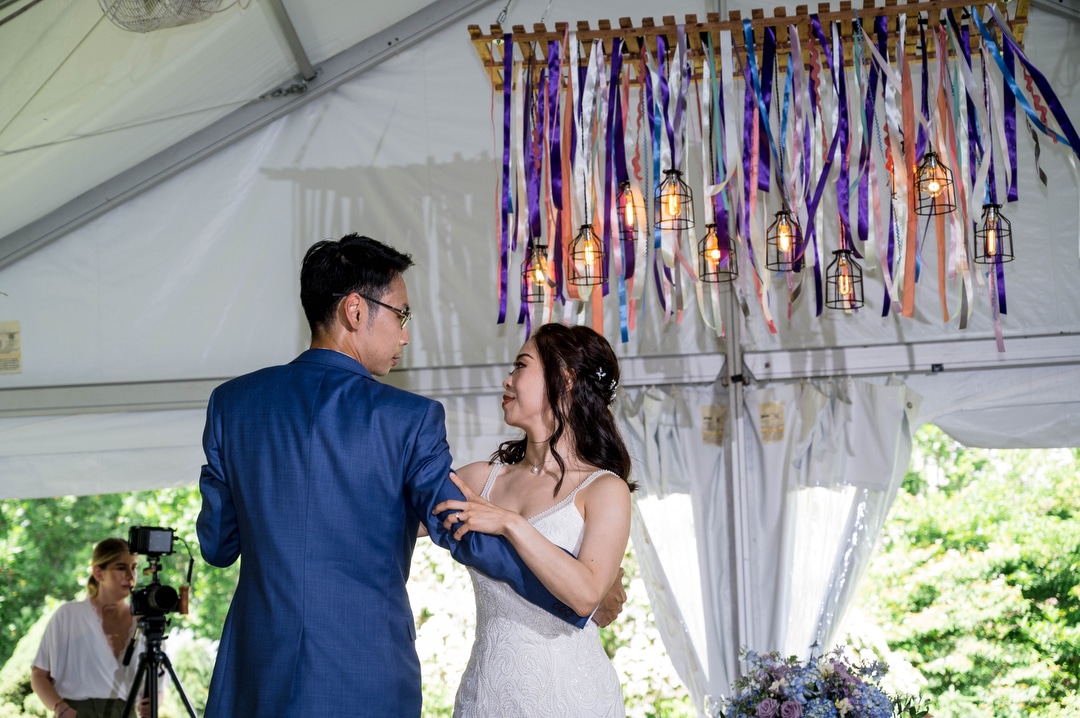 A bride and groom share a first dance in the tent in the outdoor garden at Phipps.