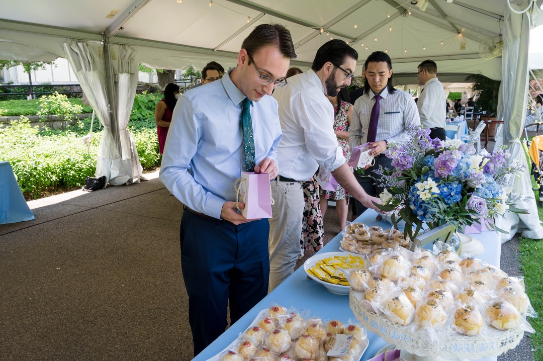 Guests fill bags at the cookie table during a Phipps outdoor wedding.
