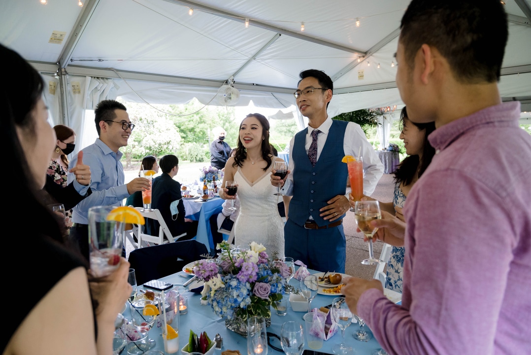 A bride and groom toast with their guests at their Phipps outdoor wedding.