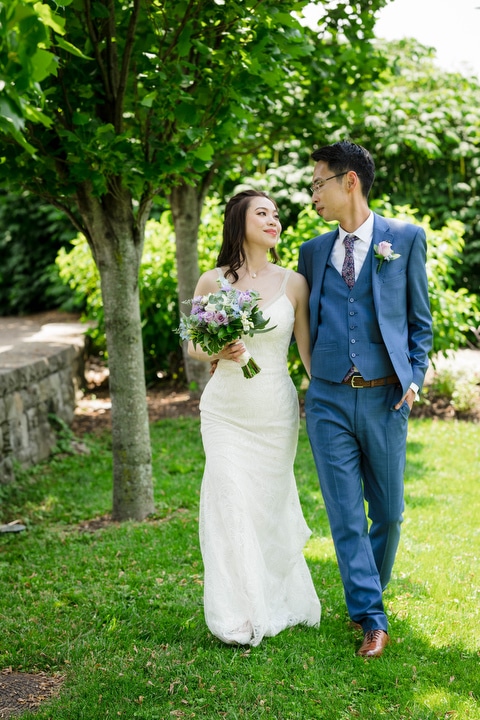 A bride and groom walk together after their Phipps outdoor wedding