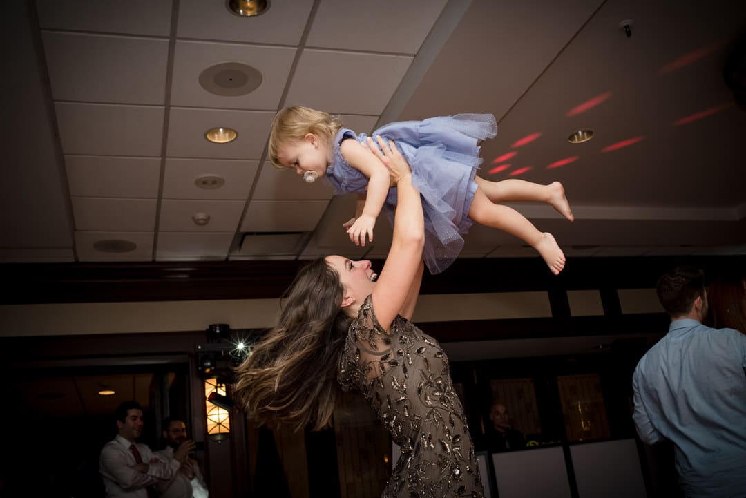 A mother lifts her toddler daughter into the air on the dance floor at the Sheraton Station Square
