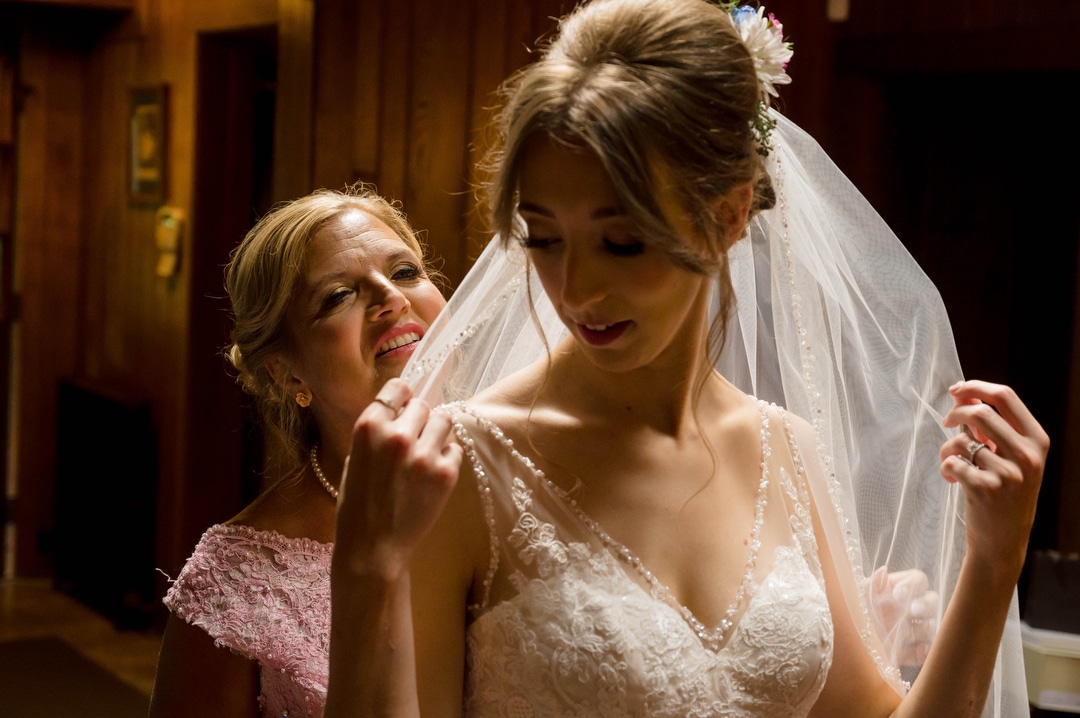 A bride's mother puts a veil on her daughter