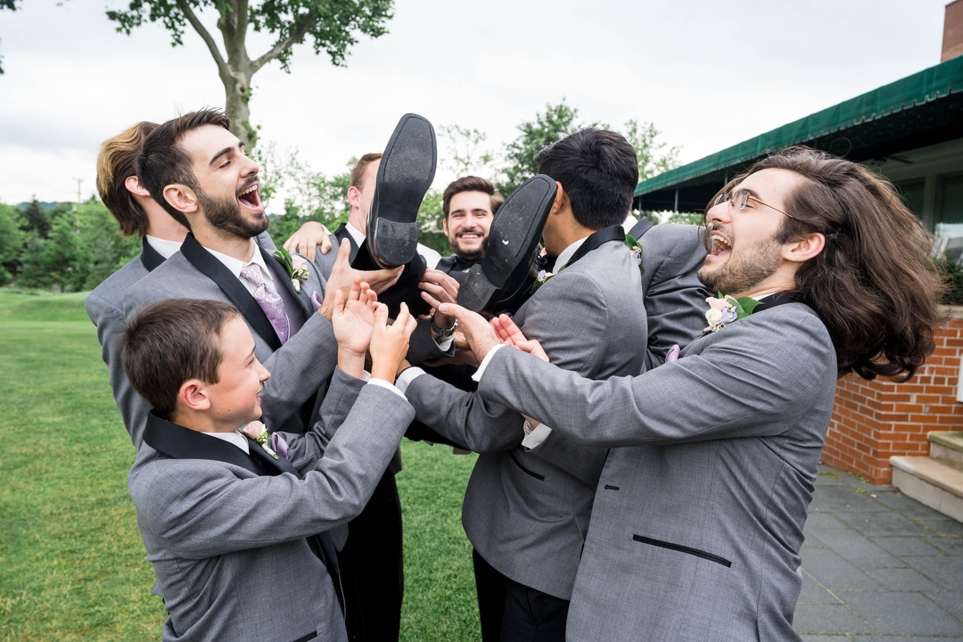 Groomsmen lift the groom into the air at an Oakmont Country Club wedding.