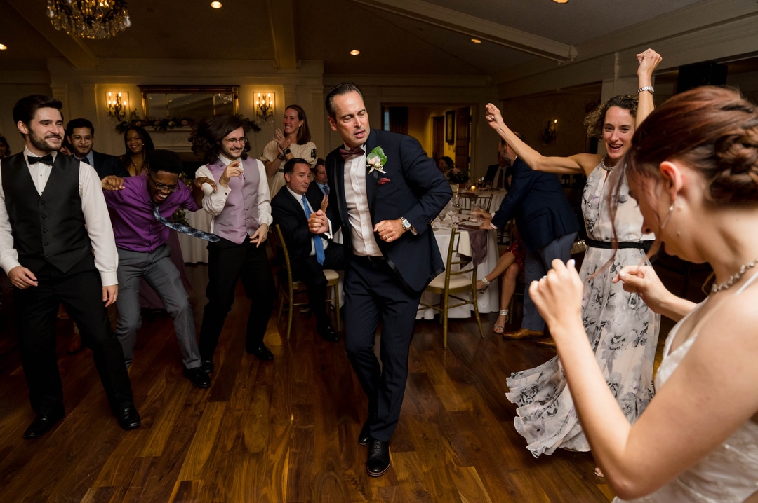 The father of the bride dances as guests cheer during a wedding at Oakmont Country Club.
