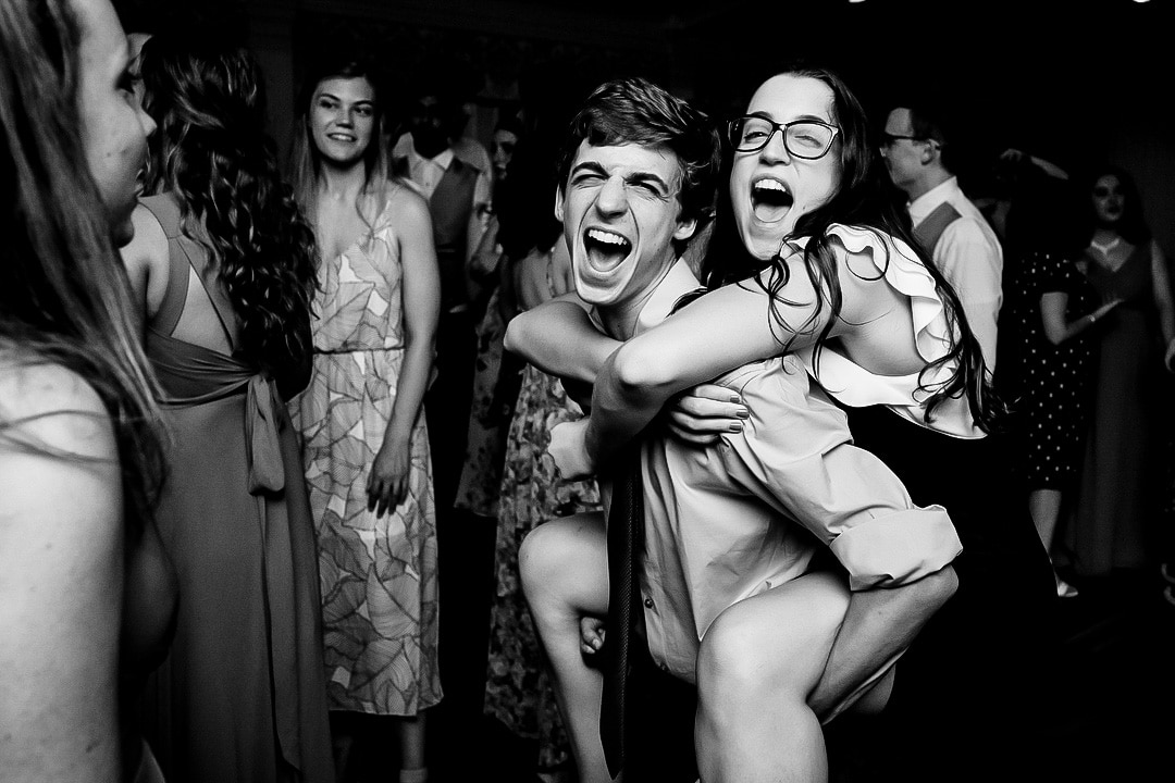 A wedding guest carries his sister on his back during a reception at Oakmont Country club.