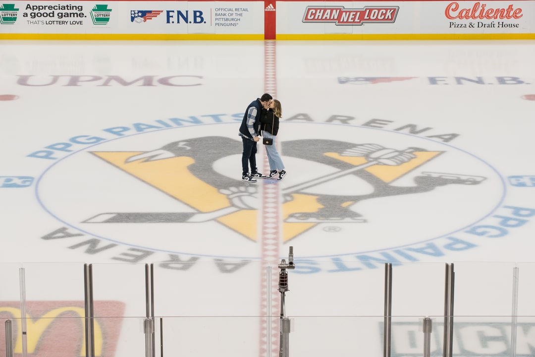A couple kisses atop the Penguins logo at center ice at PPG Paints Arena.