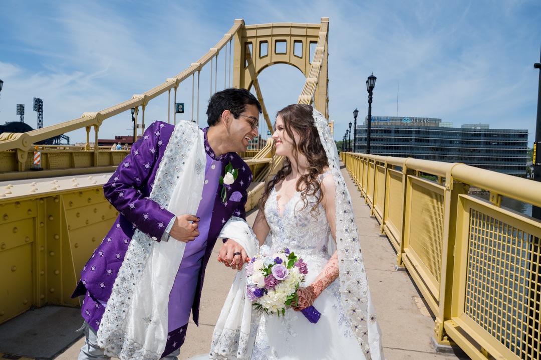 A couple kisses on the Rachel Carson Bridge in Pittsburgh before their wedding.