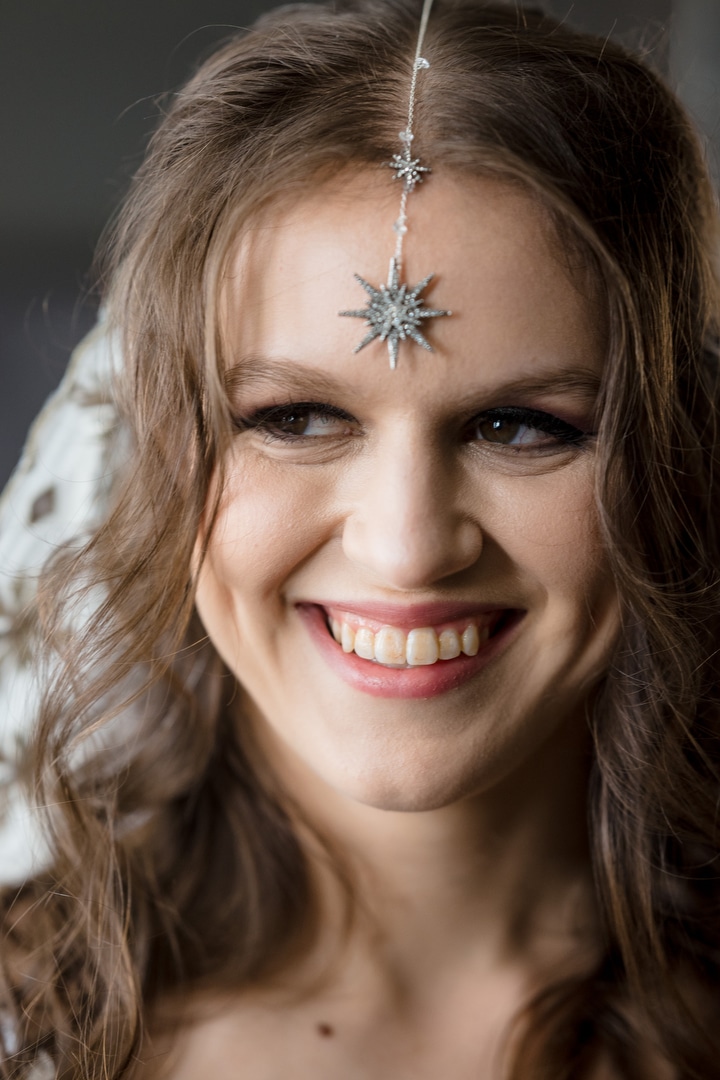 A bride smiles while wearing a star shaped pendant on her forehead at the Renaissance Hotel in Pittsburgh.