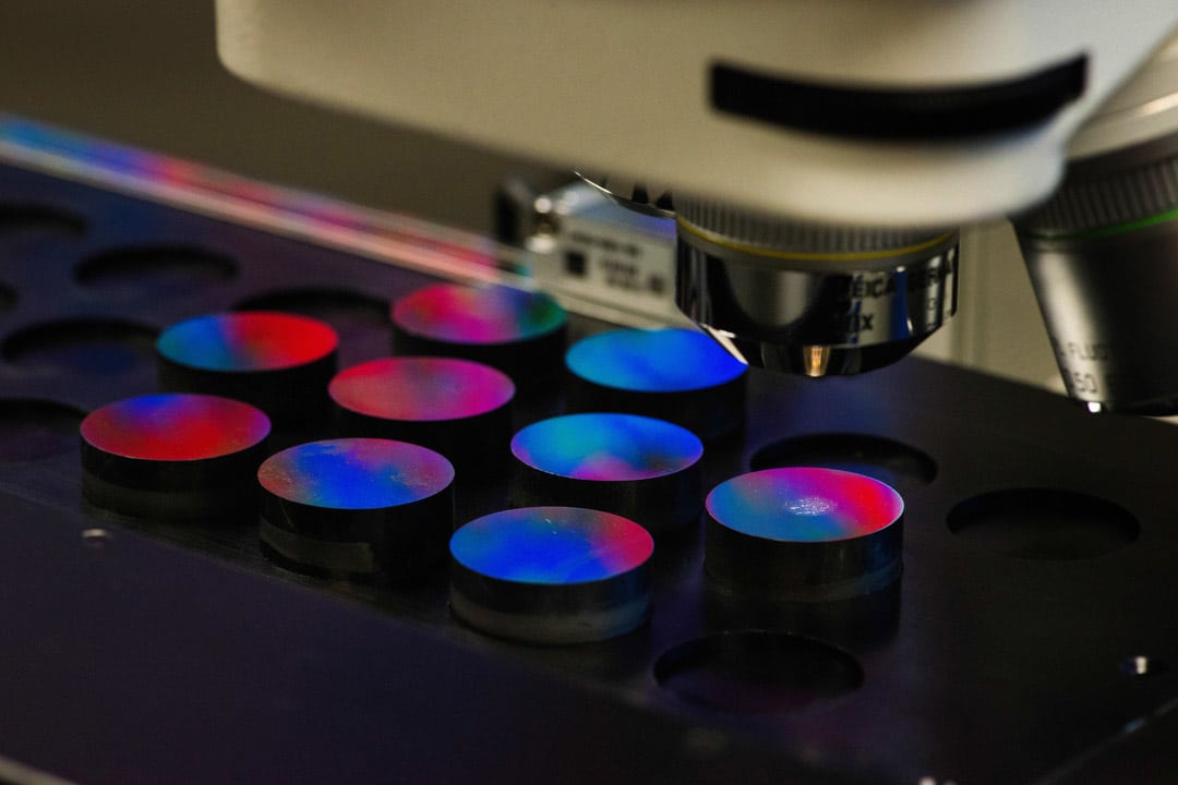 Multi-colored disks beneath a laboratory microscope.