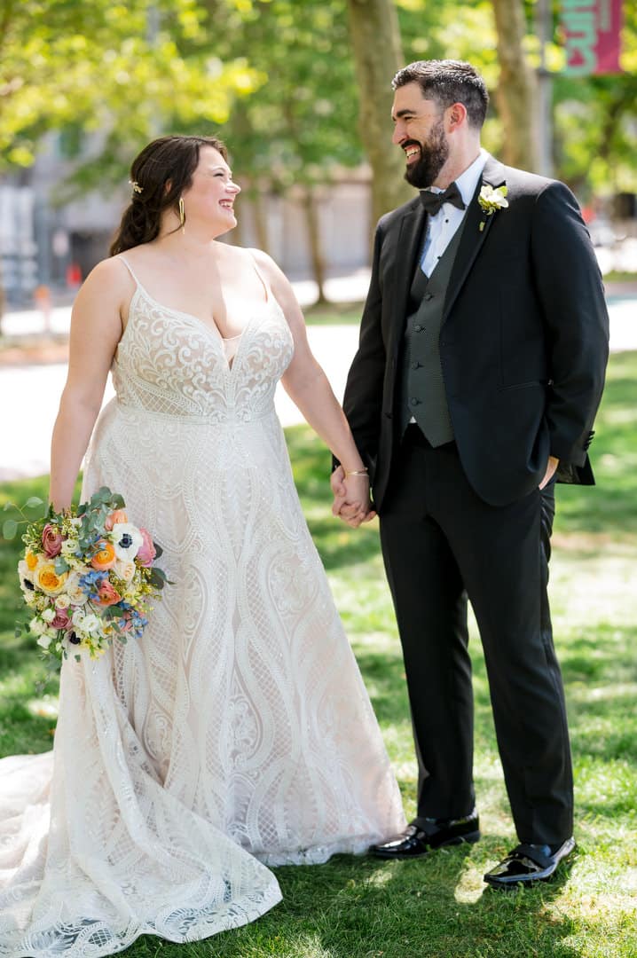 A bride and groom hold hands on a light and airy spring day in Pittsburgh.