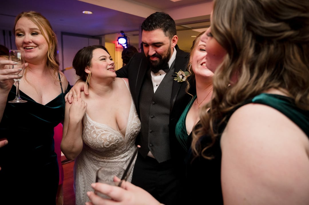 A bride and groom embrace their friends while dancing during their wedding at the Renaissance hotel in Pittsburgh.