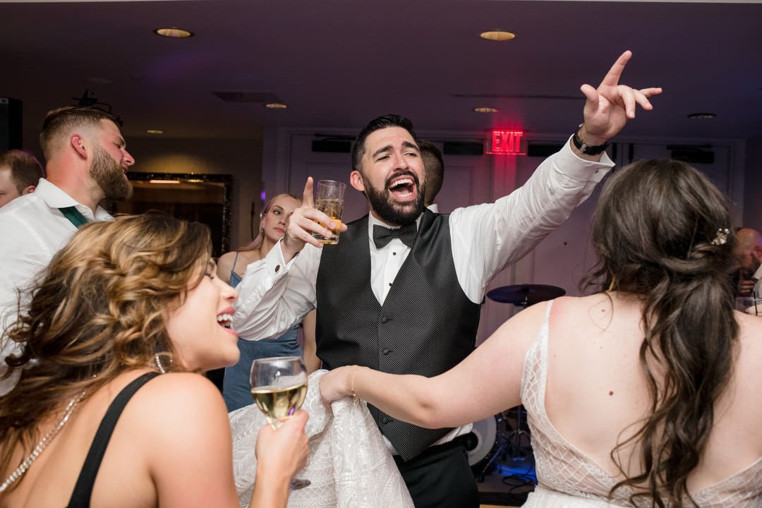 A groom holds his hands in the air as he dances during his reception at the Renaissance hotel.
