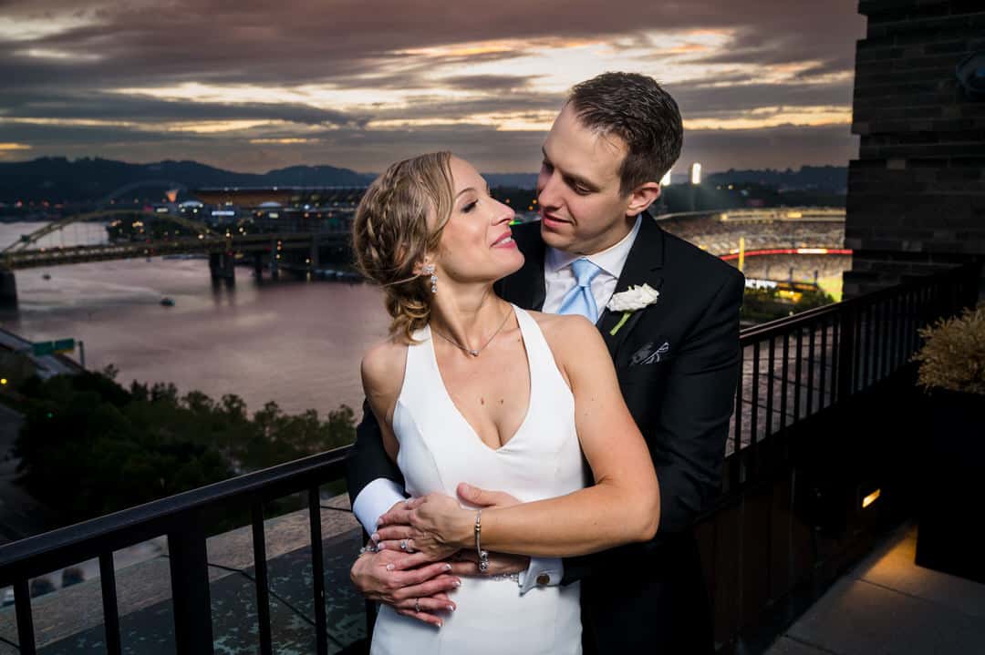 A bride looks at her groom as the sun sets over the Allegheny River during their wedding at the Renaissance Hotel in Pittsburgh.