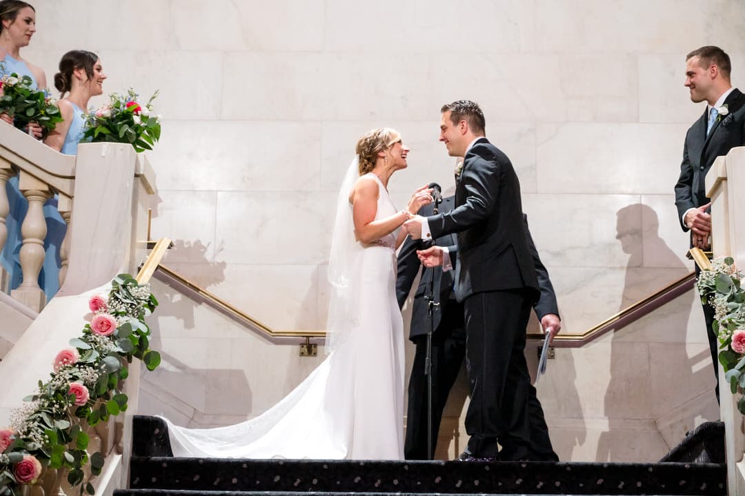 A bride and groom prepare to embrace during their wedding ceremony on the grand staircase of the Pittsburgh Renaissance hotel.