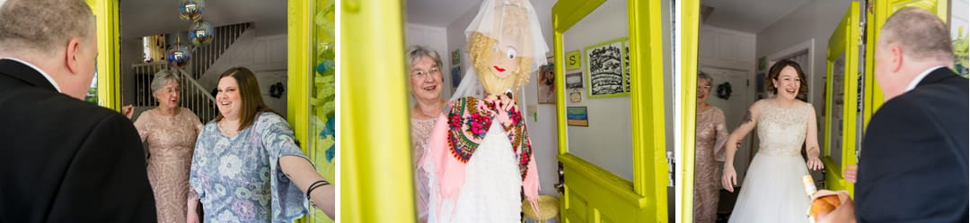 A groom stands at the front door of a house to meet his bride. He's shown two false brides including a broom in a veil and white dress before the real bride comes out.