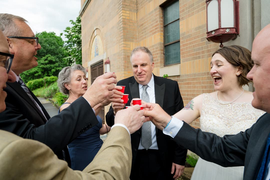A bride and groom are joined by friends as they have a toast after their wedding ceremony at Saint John Chrysostom church in Pittsburgh.