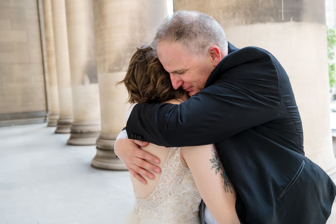 A bride and groom embrace at the Mellon Institute in Pittsburgh after their wedding.