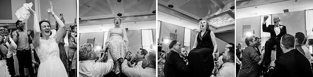 A bride cheers as her mother and her in-laws are lifted on chairs at her Saint Nicholas Cathedral Room wedding.