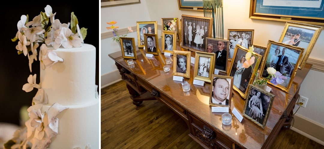 A white wedding cake with white flowers sits beside a table displaying several framed vintage family photos, each with a name card and small candles, on a polished wooden surface.