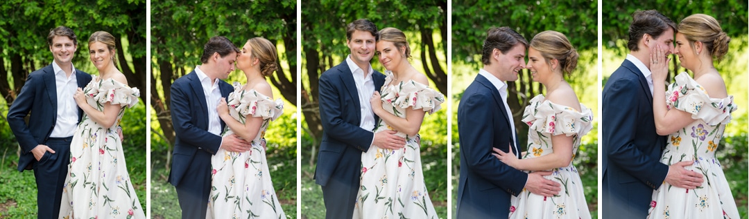 A couple poses together outdoors, dressed formally; the woman wears a white floral dress and the man wears a dark suit. They share affectionate moments, exchanging smiles, embraces, and gentle touches in a leafy garden setting.