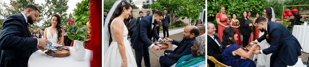 A bride and groom perform a tea ceremony outdoors, pouring tea and serving it to seated family members, with guests watching and greenery in the background.