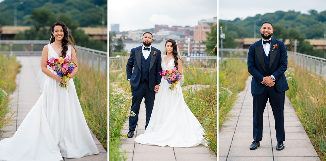 A bride in a white dress and a groom in a navy suit pose together and separately outdoors on a rooftop walkway, holding a colorful bouquet, with greenery and city buildings in the background.