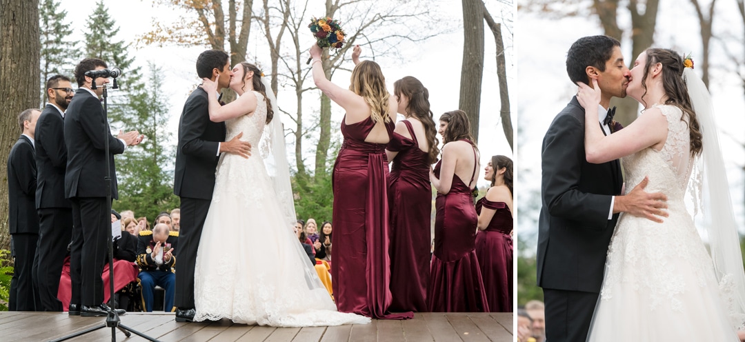 A bride and groom kiss on an outdoor wooden platform surrounded by clapping guests and bridesmaids in burgundy dresses, with trees in the background. A split image shows a close-up of their kiss on the right.