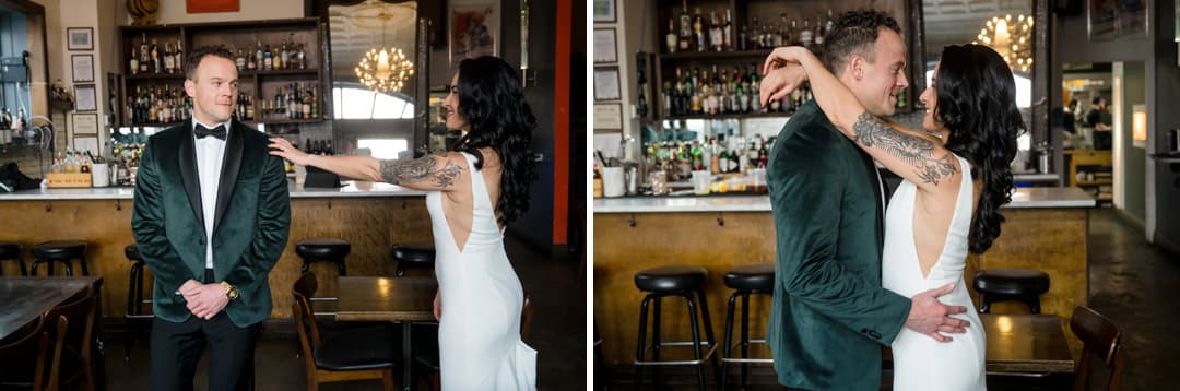 A bride and groom have their first look in a bar: In the first image, the bride approaches the groom from behind. In the second, she embraces him as they smile at each other, surrounded by bar shelves and stools.